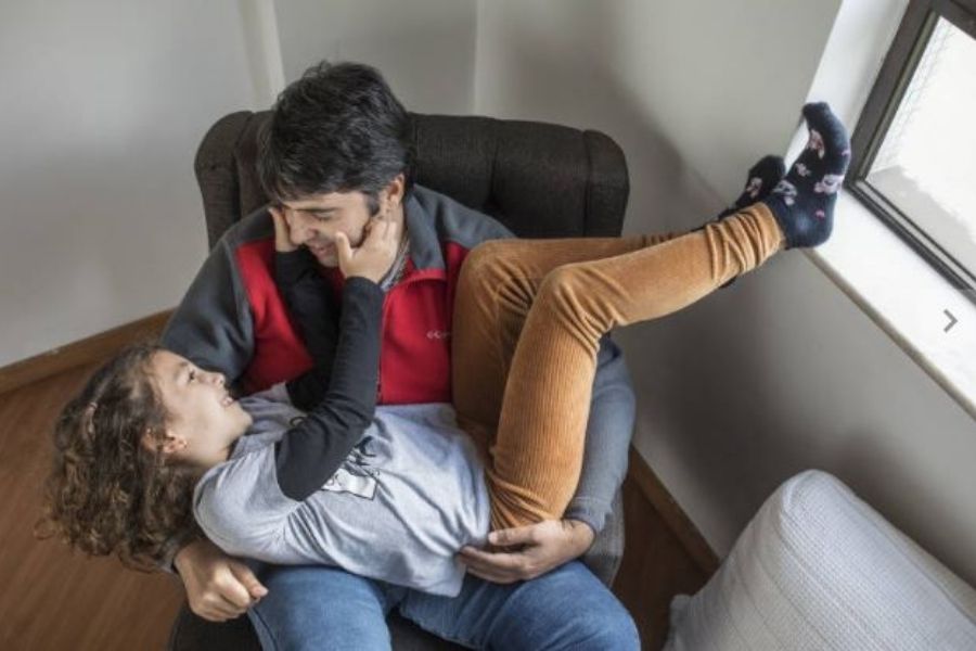 Hamilton Haddad, 46, ao lado da filha Ana, 8, no apartamento na Vila Madalena; após um AVC há 4 anos, ele teve a fala comprometida e hoje vem se recuperando com apoio da filha, que o ajuda a se comunicar (Foto: Eduardo Knapp/Folha Press)