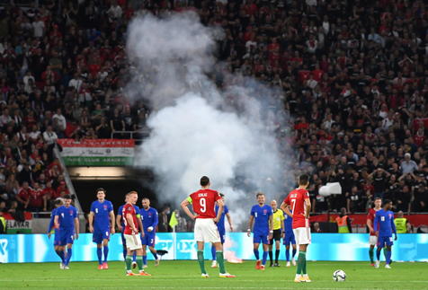 epa09444060 Players wait after a smoke bomb was thrown on the field after the third goal England scored during the FIFA World Cup Qatar 2022 qualifying Group I soccer match Hungary vs England at Puskas Ferenc Arena in Budapest, Hungary, 02 September 2021.  EPA/Tibor Illyes HUNGARY OUT