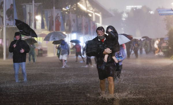 epaselect epa09442066 People navigate heavy rains and flooded walkways at the Billie Jean King National Tennis Center as the remnants of Hurricane Ida hit the area in Flushing Meadows, New York, USA, 01 September 2021.  EPA/JUSTIN LANE