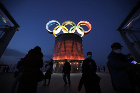 epa08988851 Visitors walk near the lit-up Olympic rings atop of the Olympic Tower in Beijing, China, 05 February 2021. The 2022 Beijing Winter Olympics are scheduled to take place from 04 to 20 February 2022.  EPA/WU HONG