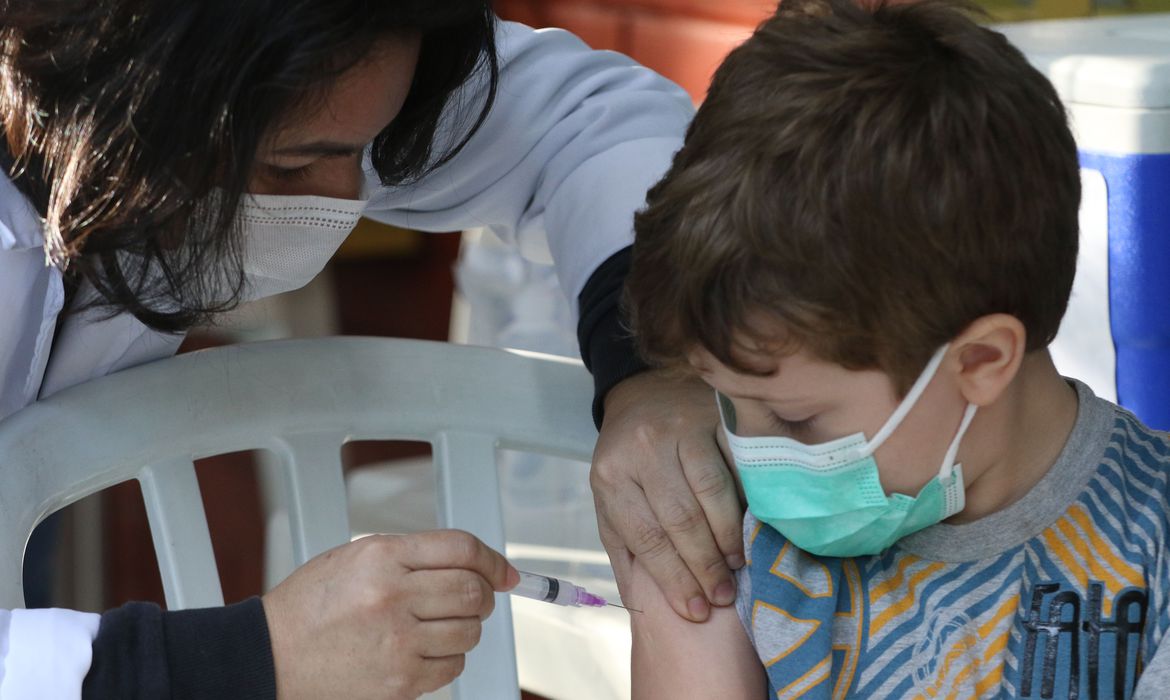 O menino Thomas Schneider, 4 anos, toma sua primeira dose de vacina contra a Covid-19  no Centro Municipal de Saúde Píndaro de Carvalho Rodrigues, na Gávea, zona sul da cidade. A cidade do Rio inicia hoje(15) a vacinação de crianças de 4 anos de idade contra a covid-19.