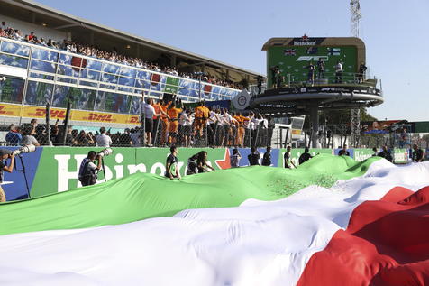 epa09463747 Formula One fans wave a giant Italian flag during the podium ceremony for the Formula One Grand Prix of Italy at the Autodromo Nazionale Monza race track in Monza, Italy, 12 September 2021.  EPA/LARS BARON / POOL