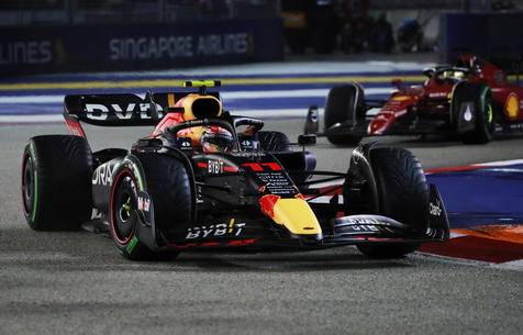 epa10219553 Mexican Formula One driver Sergio Perez of Red Bull Racing (L) and Monaco's Formula One driver Charles Leclerc of Scuderia Ferrari in action during the Singapore Formula One Grand Prix race at the Marina Bay Street Circuit, Singapore, 02 October 2022.  EPA/TOM WHITE