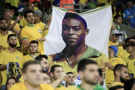 epa06257920 Fans of the Brazilian national soccer team cheer while holding a banner showing the face of retired soccer player Pele before the FIFA World Cup 2018 CONMEBOL qualifier soccer match between Brazil and Chile at the Allianz Park in Sao Paulo, Brazil, 10 October 2017.  EPA/FERNANDO BIZERRA JR.