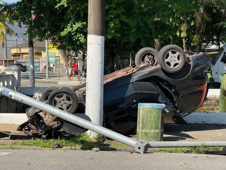 Carro danifica poste e cai em canal após capotar em avenida de Santos