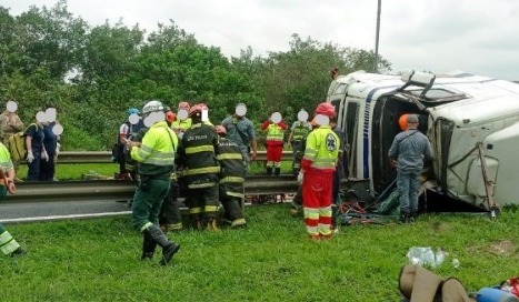 Caminhão tomba na rodovia e motorista fica preso nas ferragens