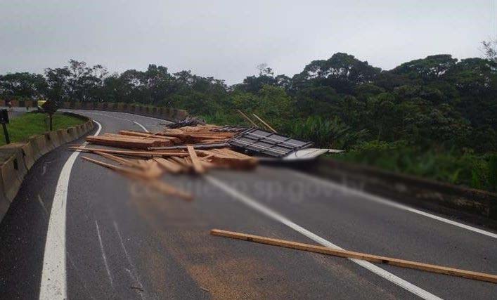 Carreta com 23 kg de madeira tomba e derrama carga na Anchieta