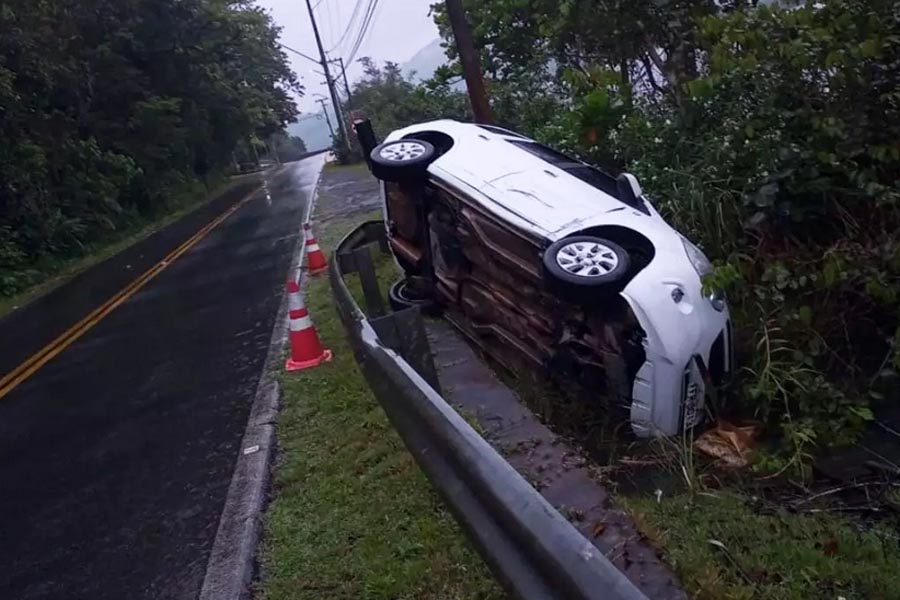 Veículo capota e fica preso entre muro de proteção e árvores em rodovia de Guarujá