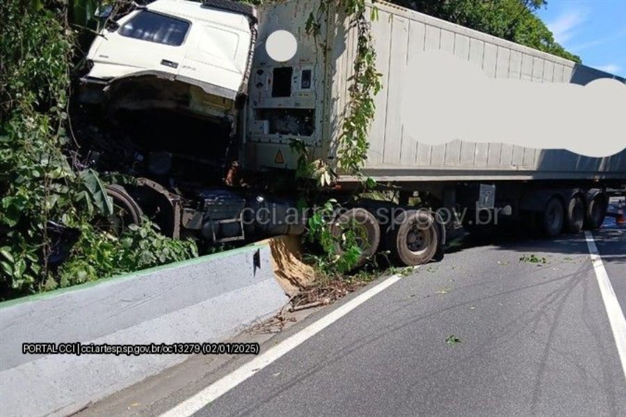 Caminhão é atingido por carreta e se choca contra barreira de concreto