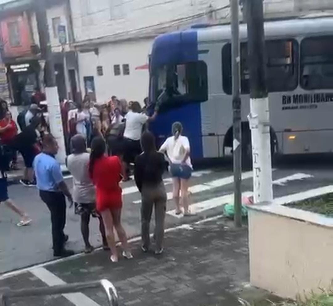 Motociclista fica ferida após colisão com ônibus e moto fica sob o coletivo em São Vicente