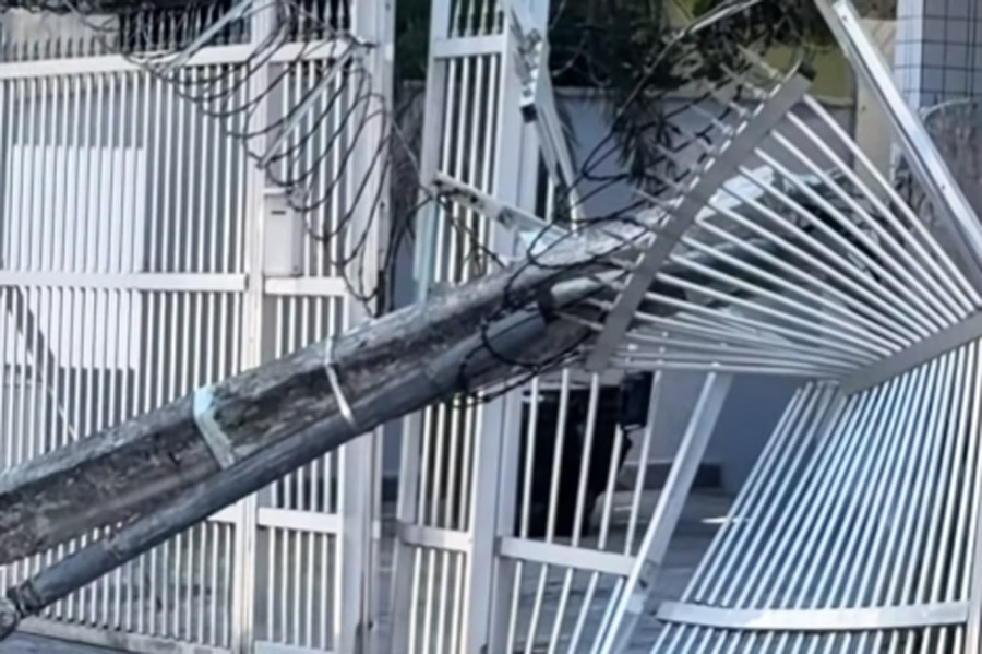 Poste é derrubado por caminhão e cai sobre portão de prédio em Praia Grande