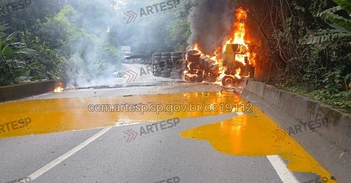 Carreta com suco de laranja perde freio, atinge moto e pega fogo na Anchieta, em Cubatão