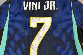 Travis Scott torce pelo Brasil durante jogo de estreia e ganha camisa autografada de Vini Jr.
